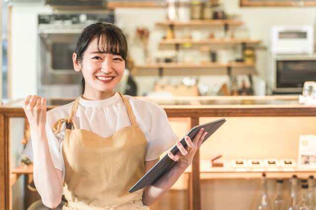 カフェでタブレットを持つ女性店員