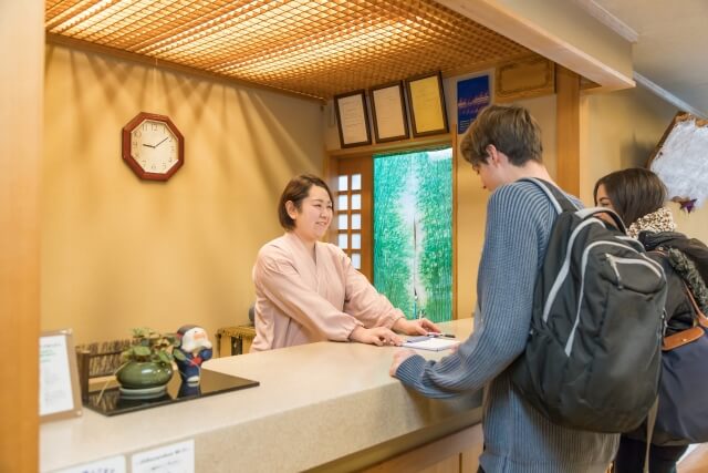 旅館でチェックインする観光客